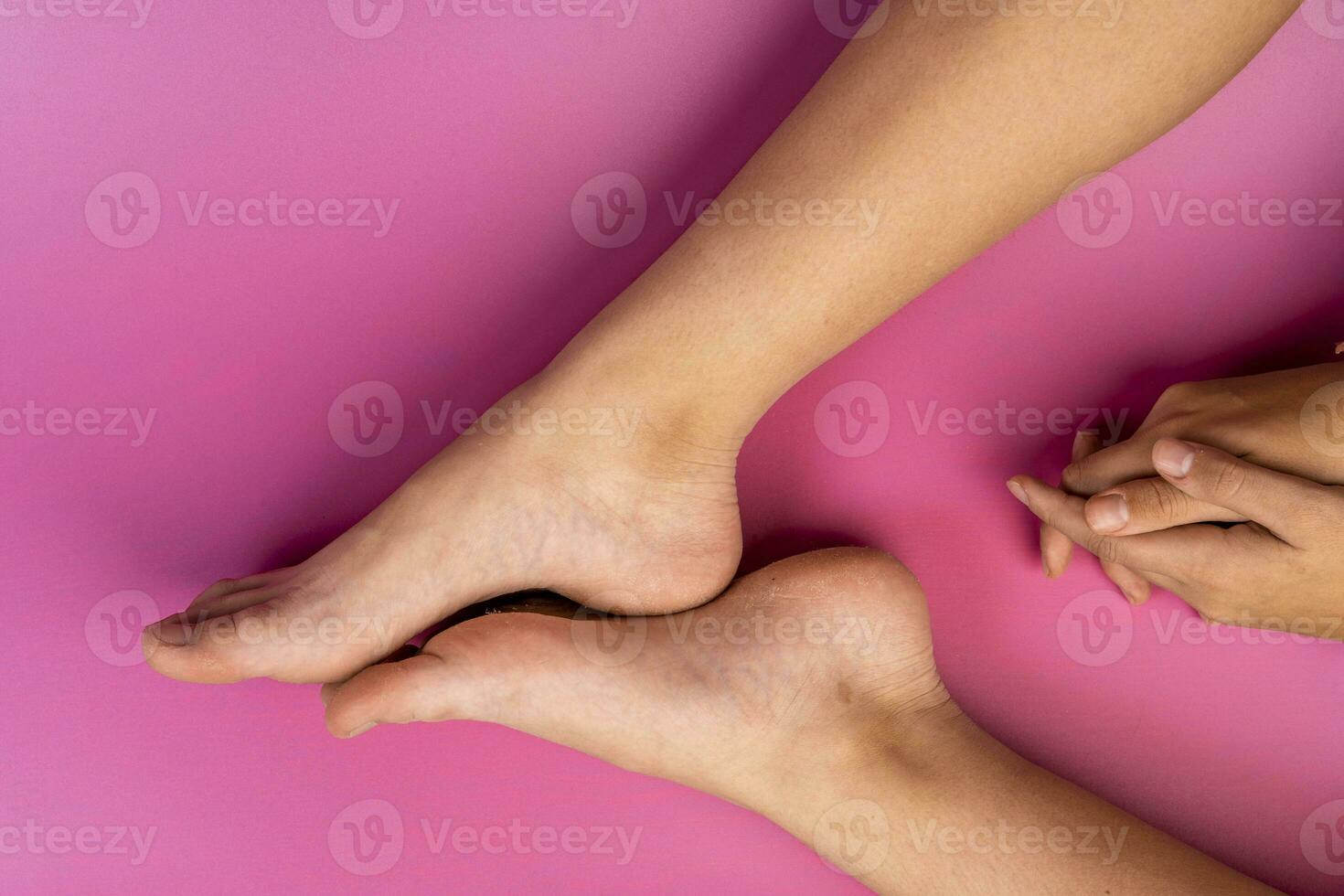 beautiful natural legs and arms of a teenage girl on a pink background photo