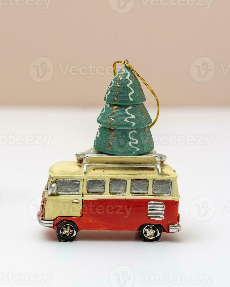 toy car is carrying a toy Christmas tree. Christmas tree and a minibus photo
