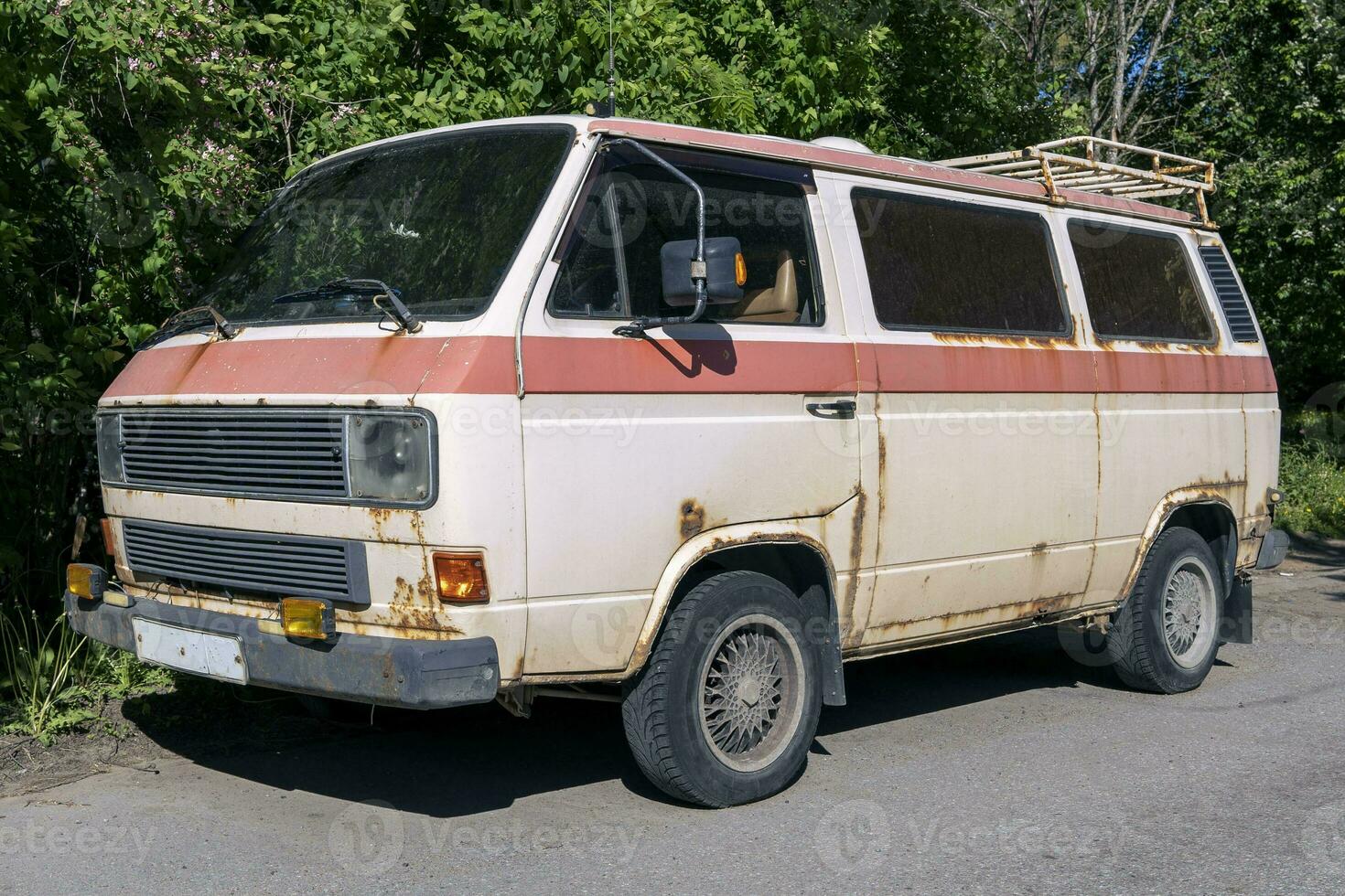 an old vintage rusty minibus standing in the yard. hippie culture photo