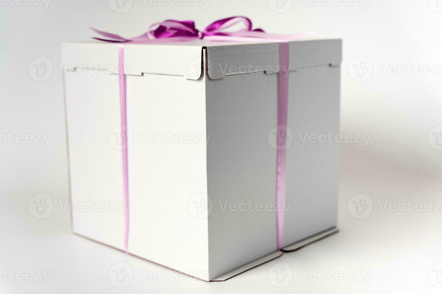 large white gift box tied with a red ribbon on a white background photo