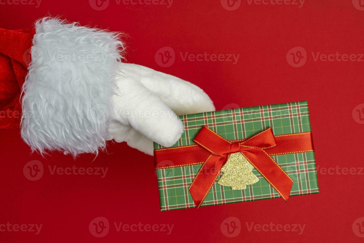 Santa's hands are holding a gift for Christmas. red background photo
