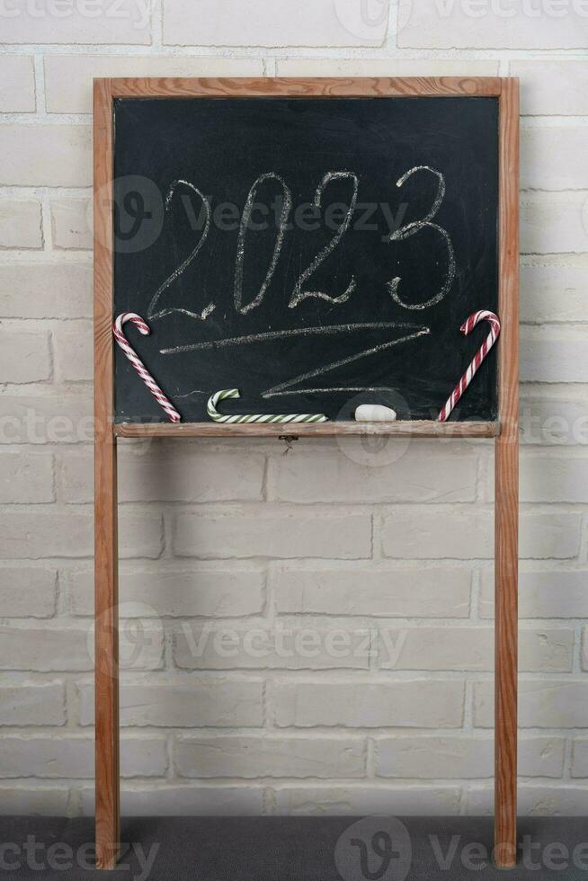 a black slate on which the year 2023 is written in chalk. Happy New Year. photo