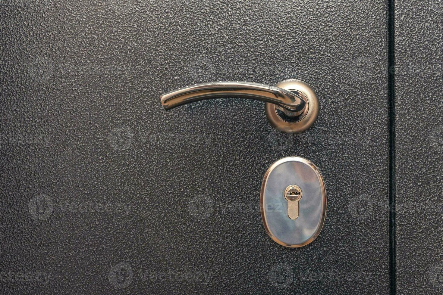 modern reliable metal door. shiny handle, lock. close-up. copy space photo