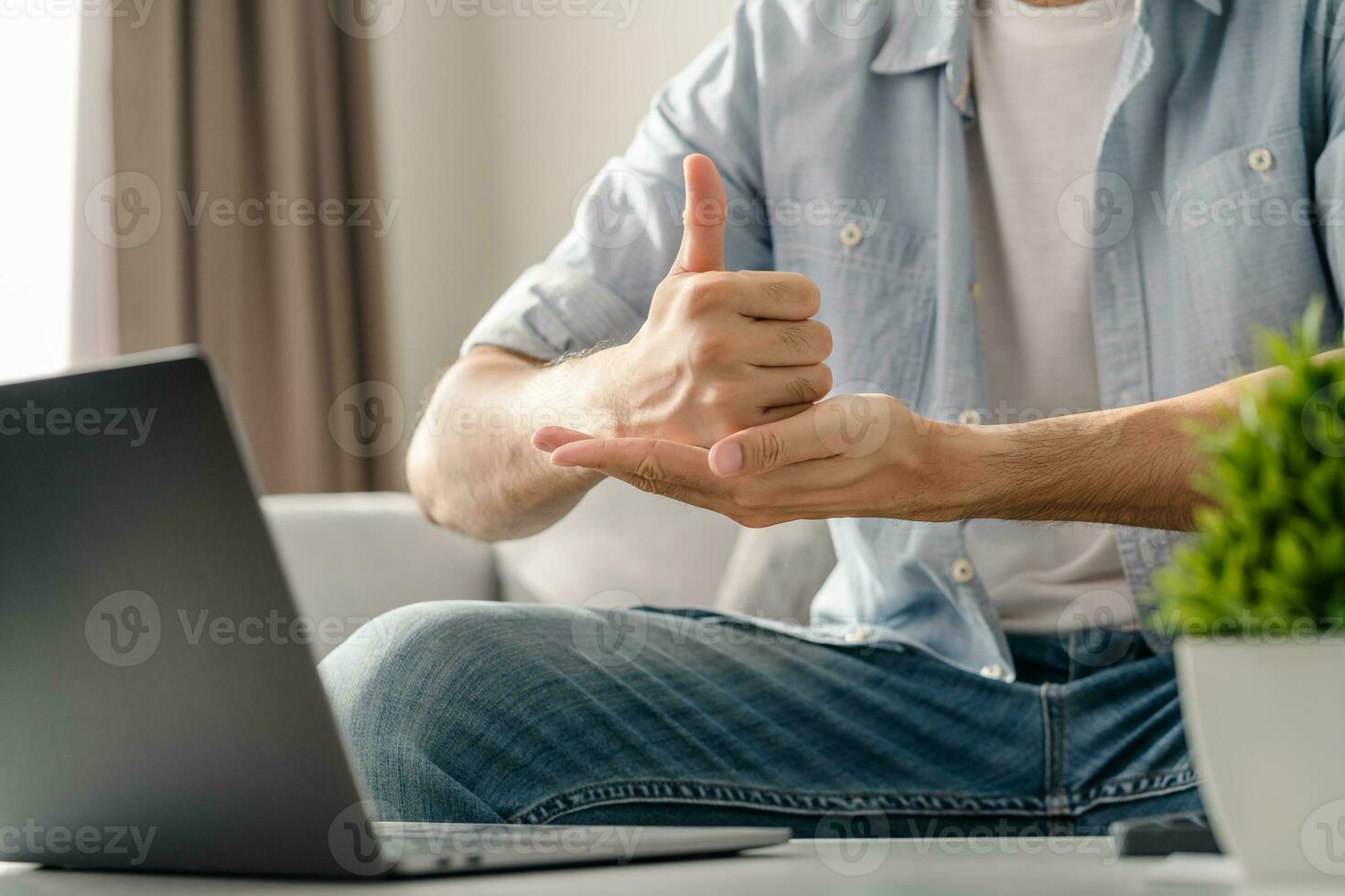 Young deaf man using laptop computer for online video conference call learning and communicating in sign language. photo