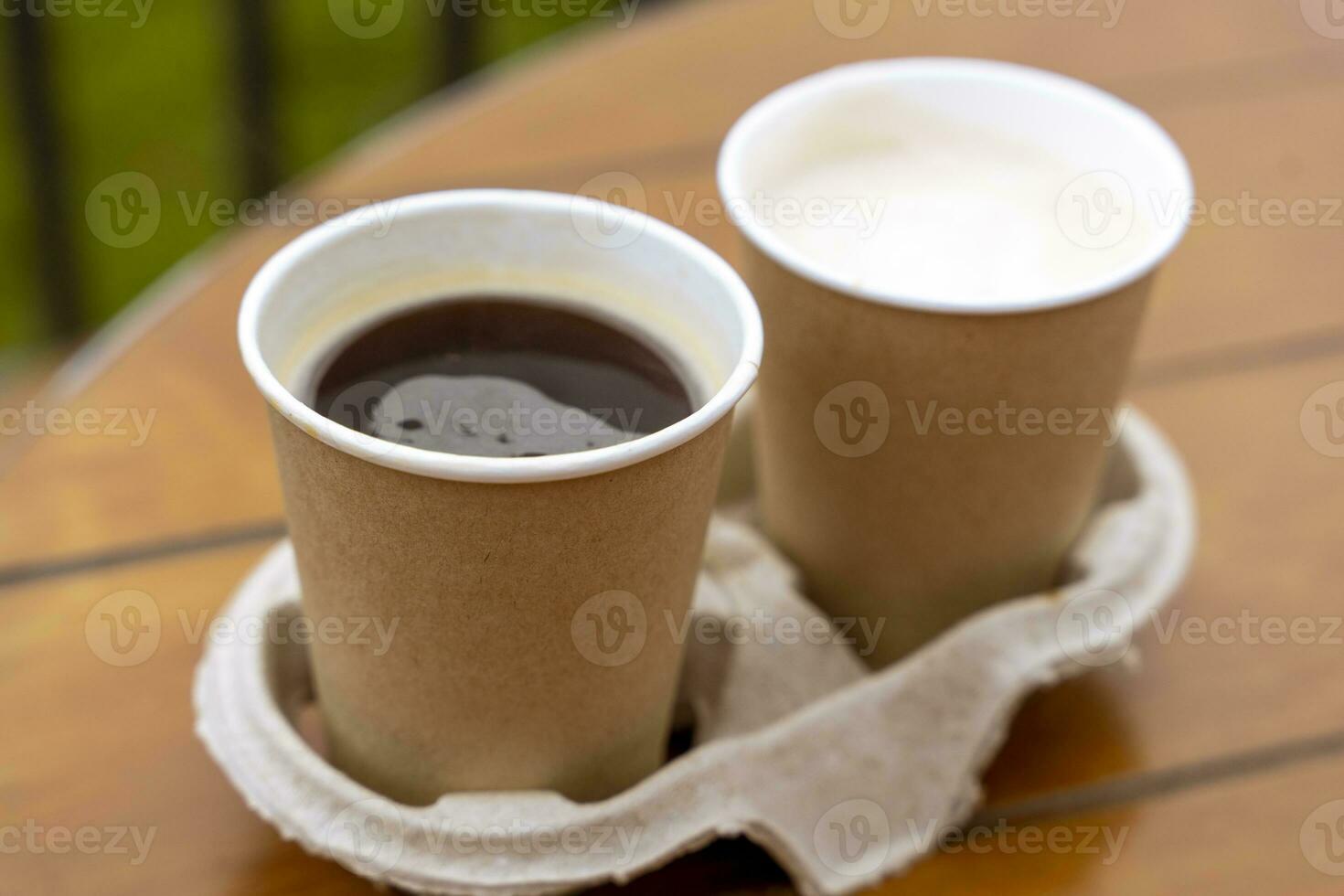 paper cups with coffee on the table of an outdoor cafe. Takeaway food. photo