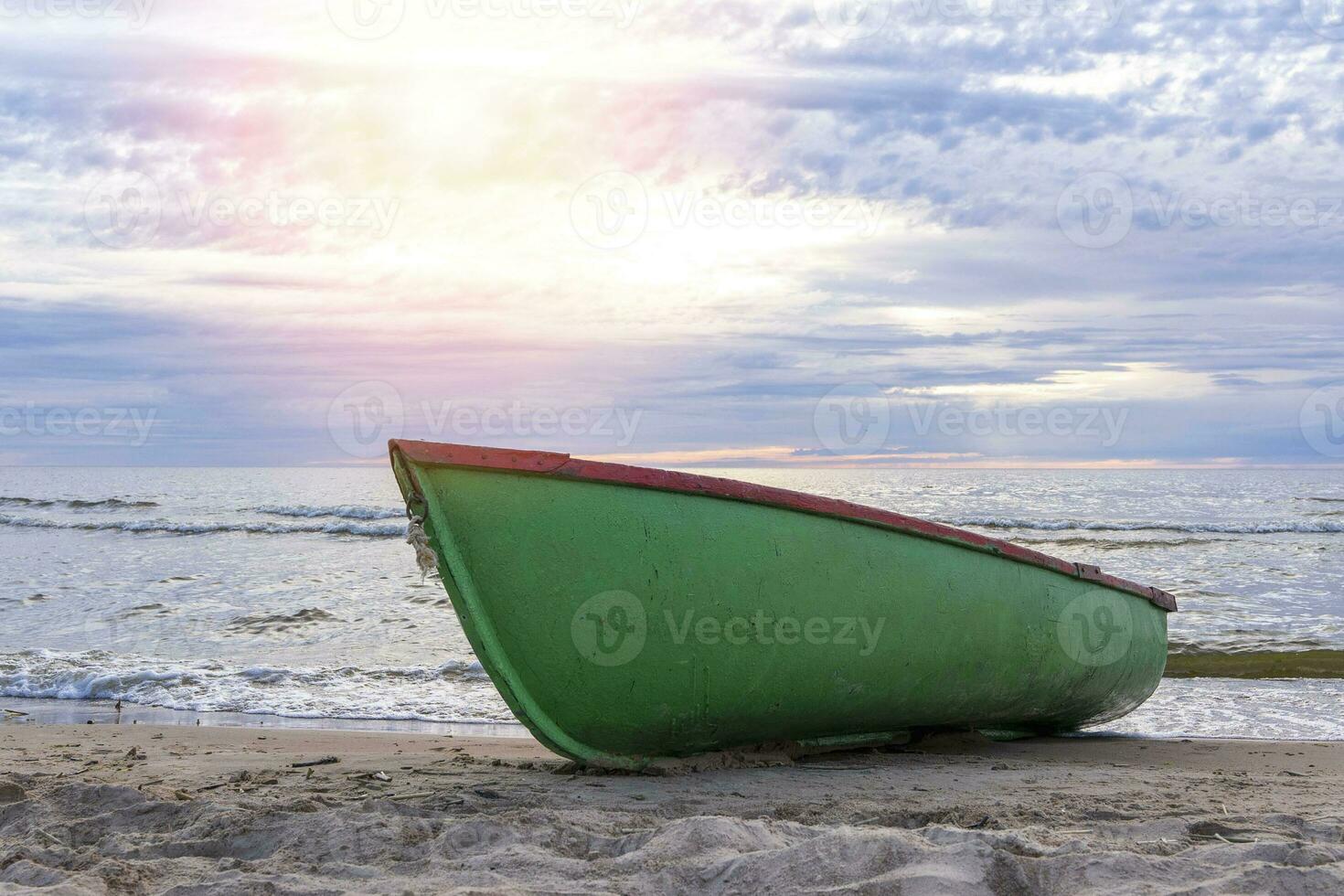 wooden fishing boat pulled onto the sand of the shore of the sea bay photo