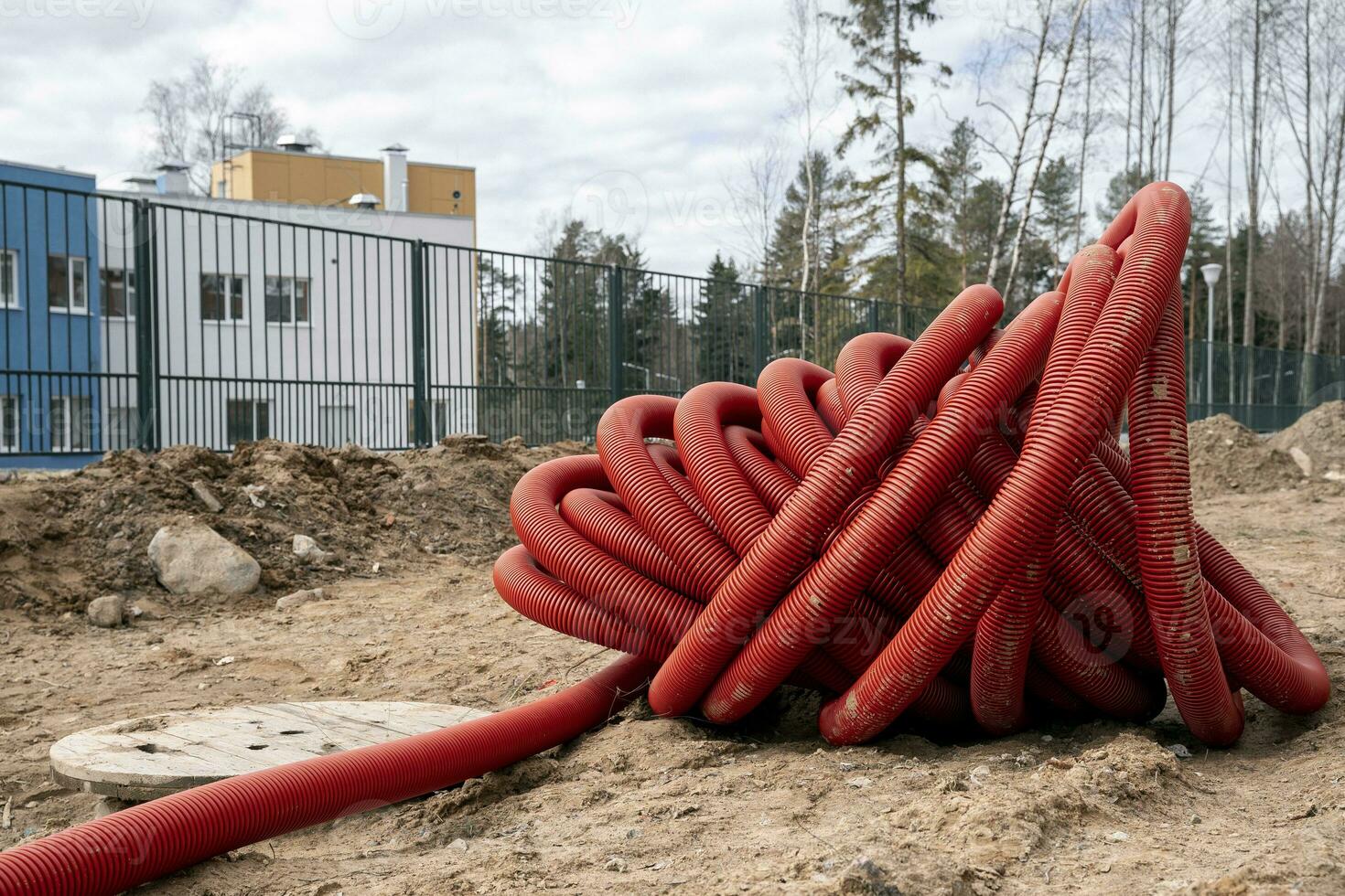 rolled up red corrugated PVC pipe for laying electrical cables photo