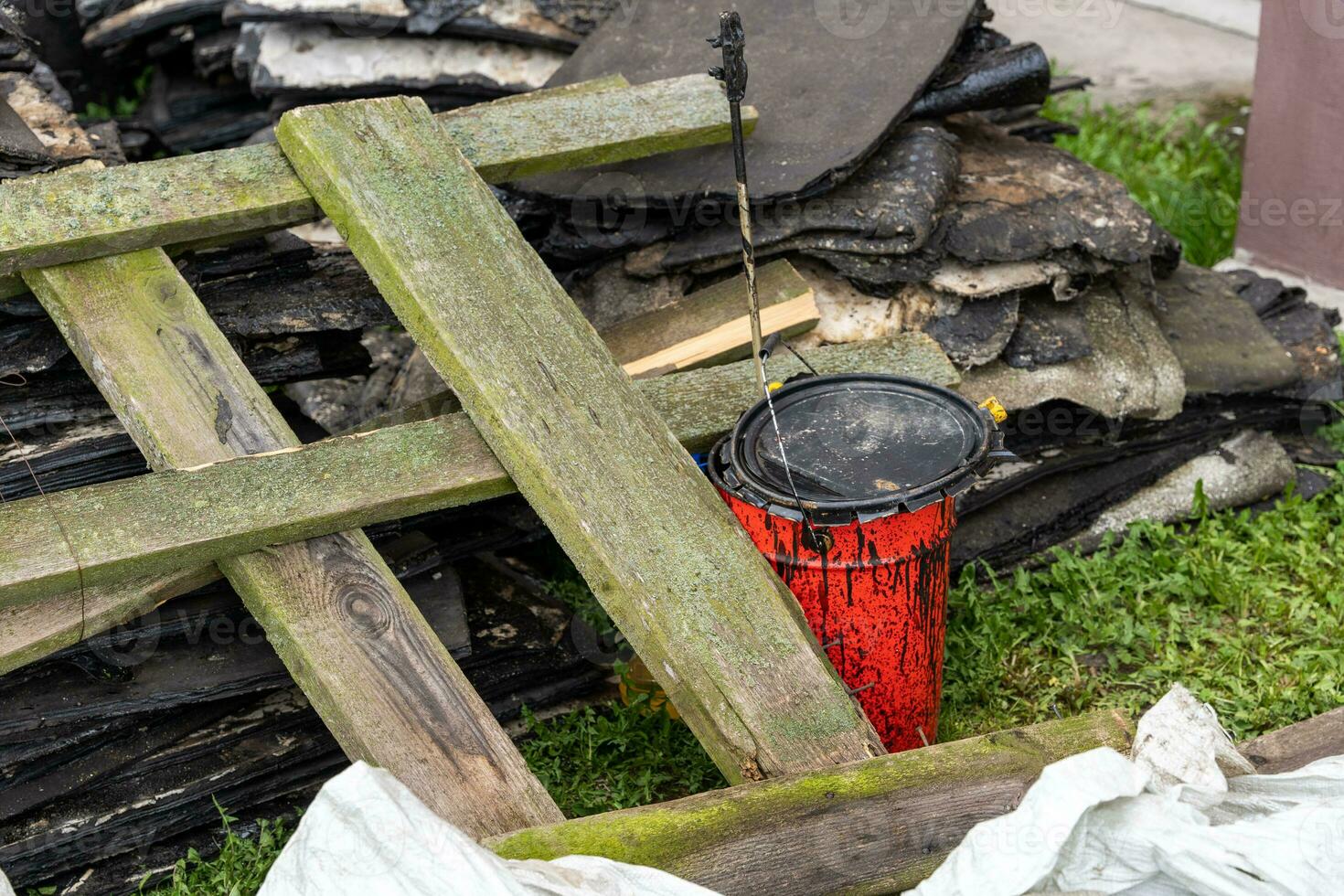 debris left after the repair of the roof. red bucket with mastic photo
