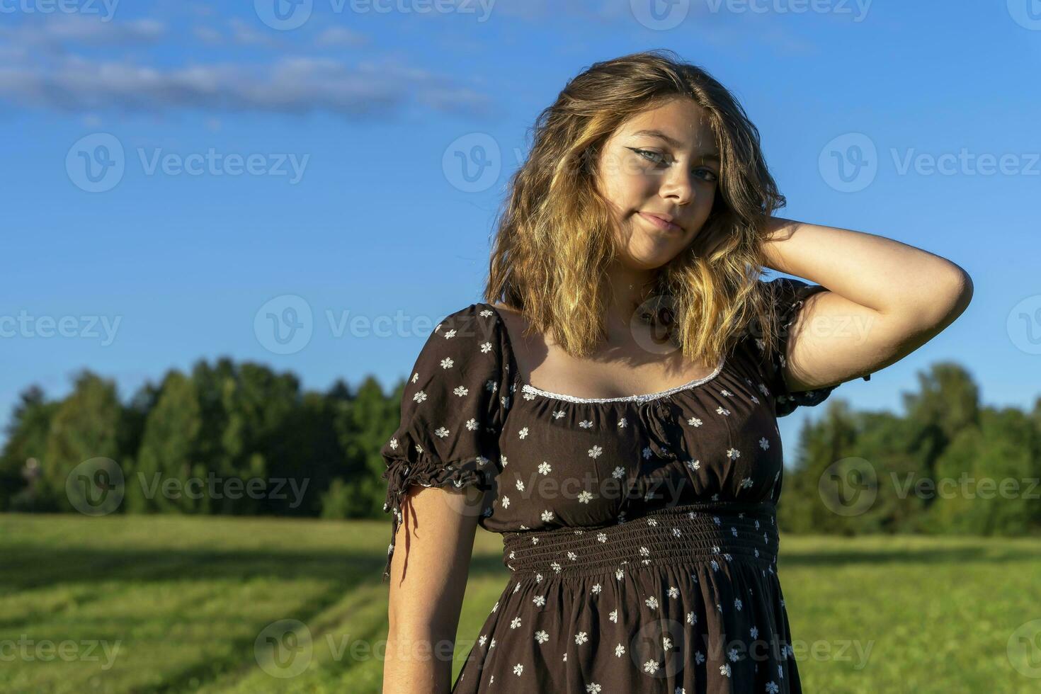 hermosa niña en vestir en el antecedentes de un verde campo en verano foto