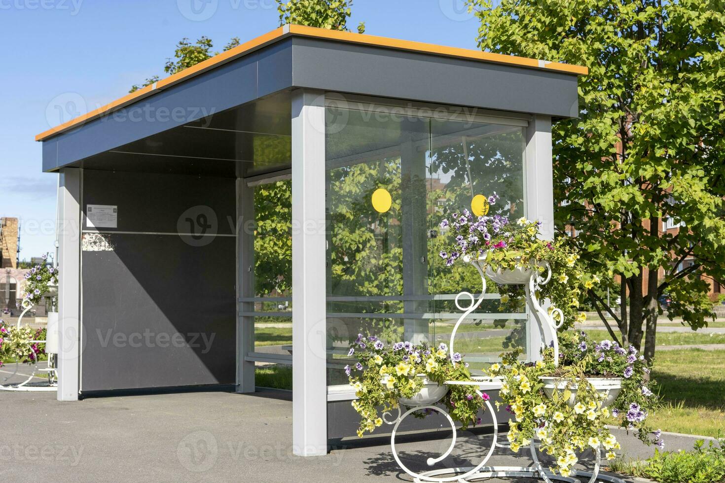 An empty bus stop decorated with beautiful flowers in pots and vases photo