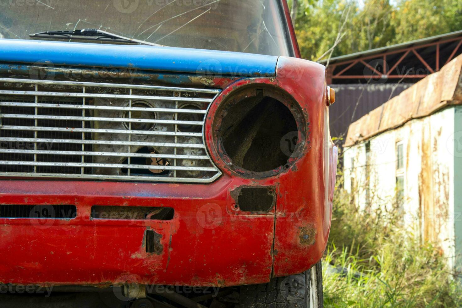 un antiguo roto clásico coche abandonado en el calle. inoxidable antiguo máquina foto