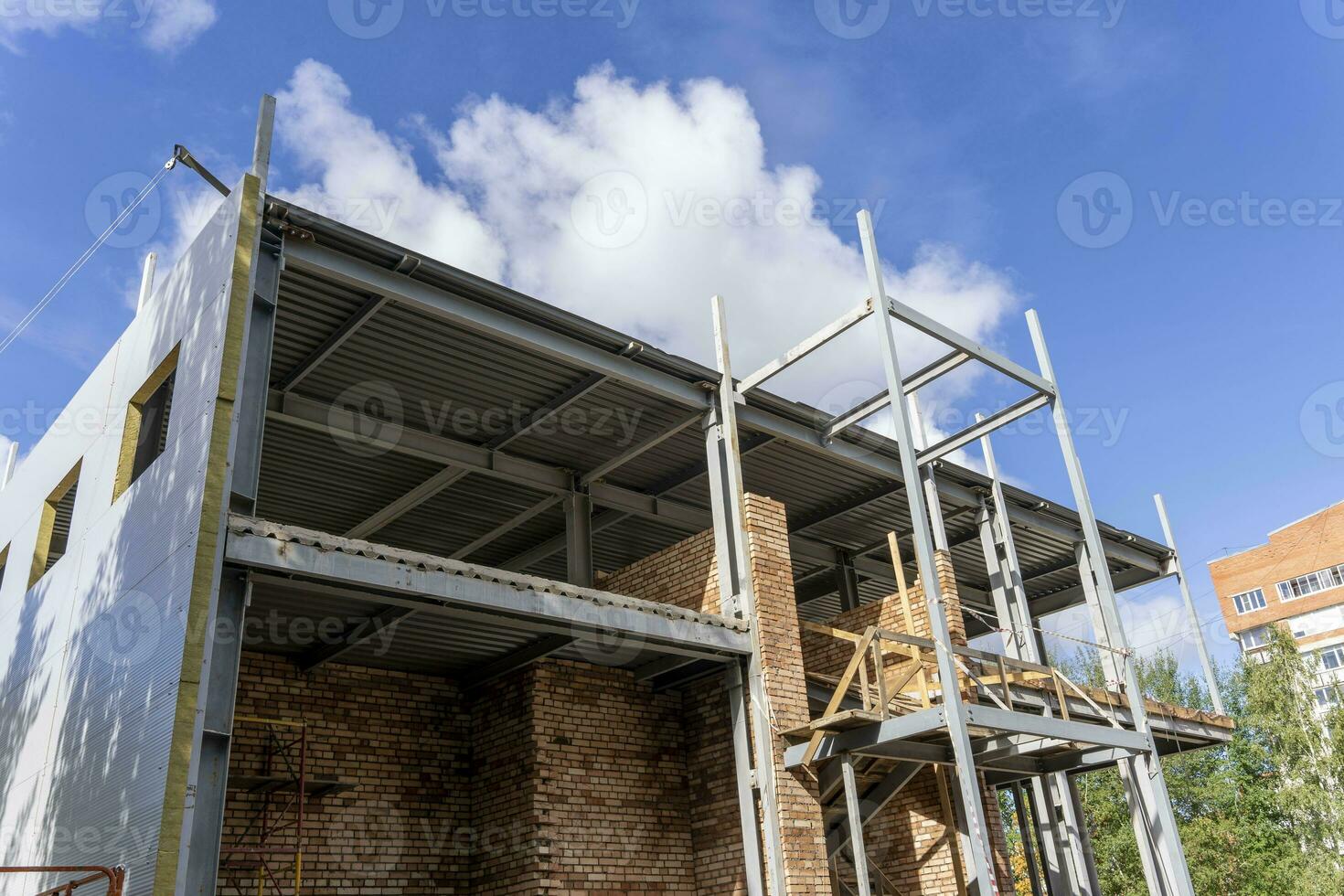 The metal frame of the new building with insulation and sandwich panels photo
