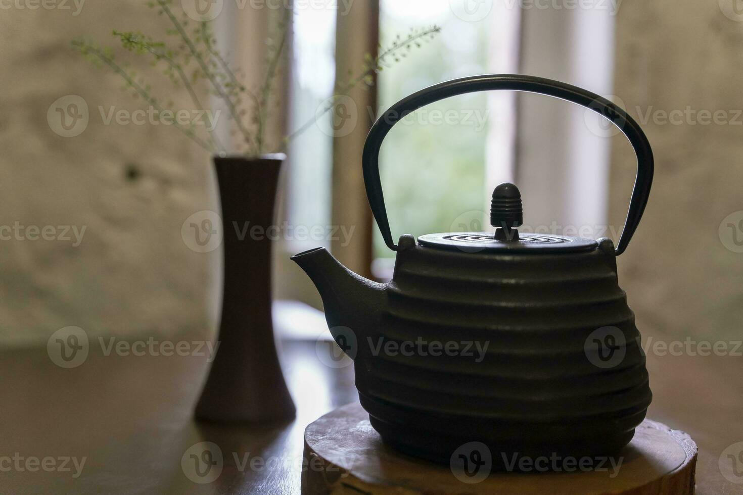 cast-iron kettle on a wooden stand on the restaurant table photo