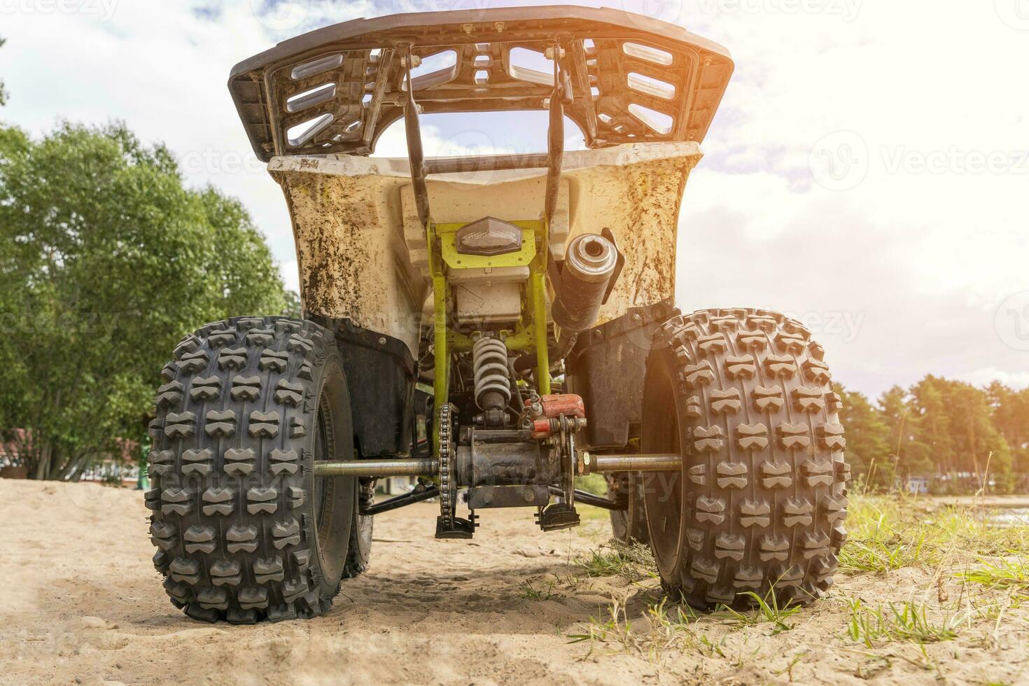 Rear view of the ATV standing on sandy ground photo