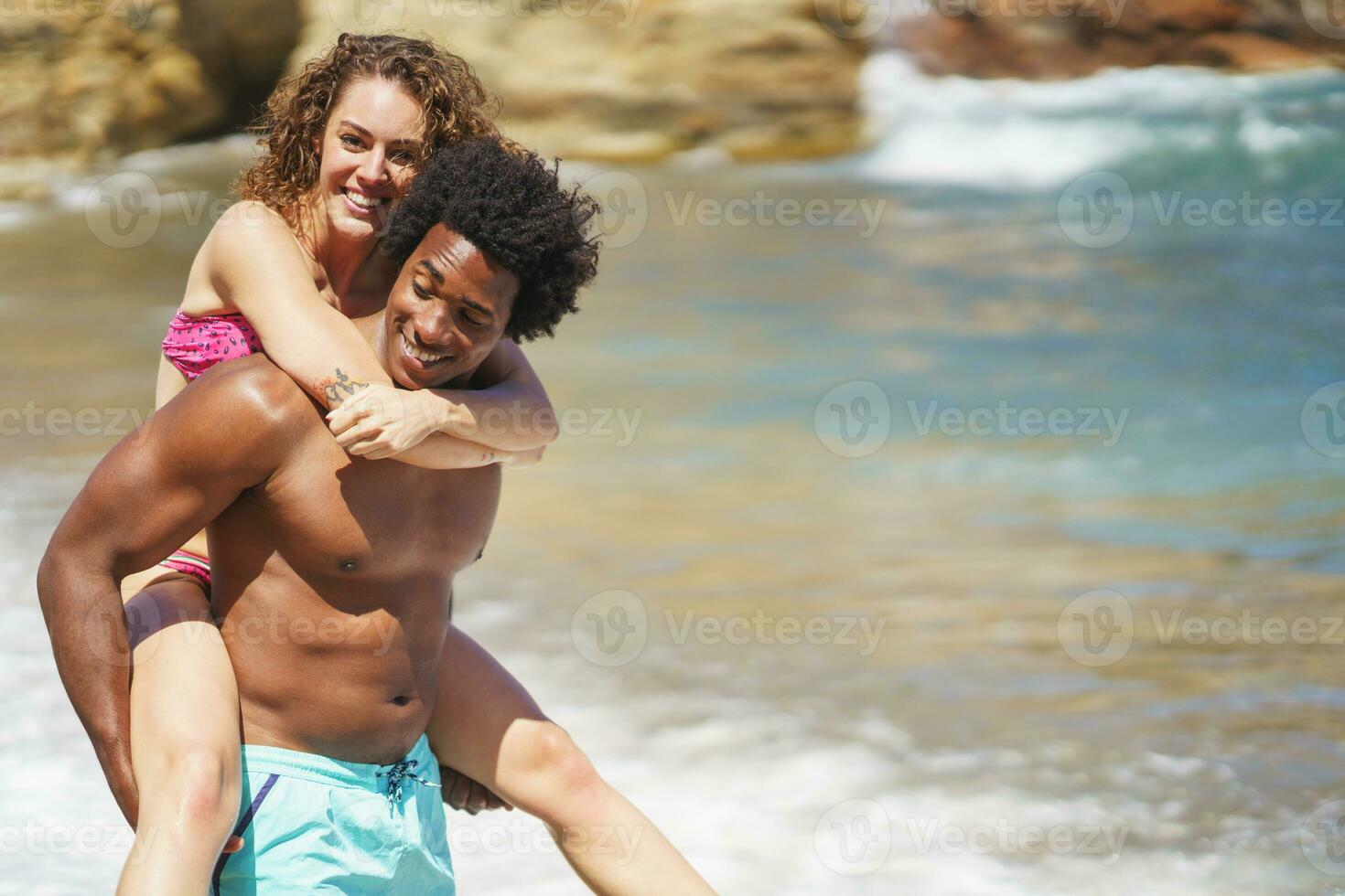 Cheerful woman holding on to boyfriends head while having piggyback ride  stock photo