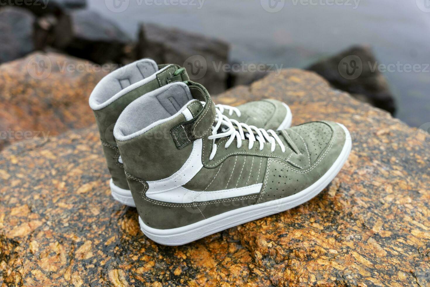 new fashionable high youth sneakers on a stone background photo