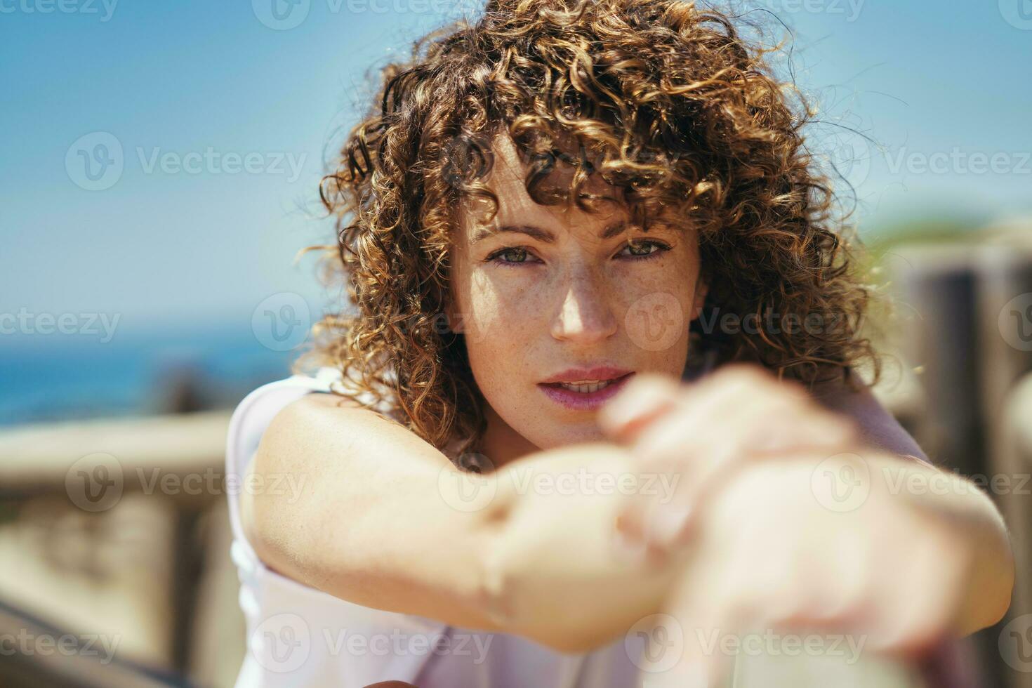 Young woman stretching arms on bridge photo