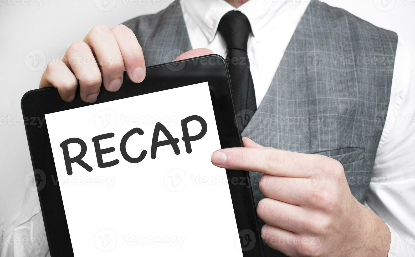 Businessman showing business concept on tablet standing in office RECAP photo