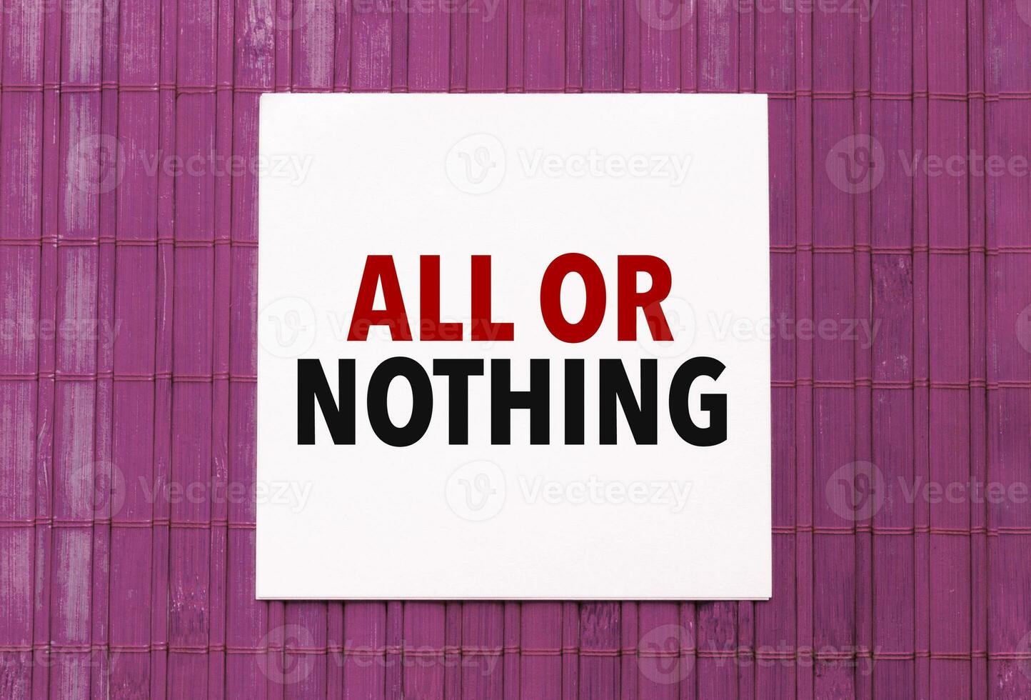 blank note pad with text ALL OR NOTHING on blue wooden background photo