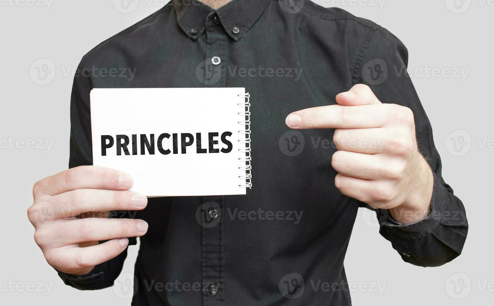 Businessman holding a white notepad with text PRINCIPLES, business concept photo