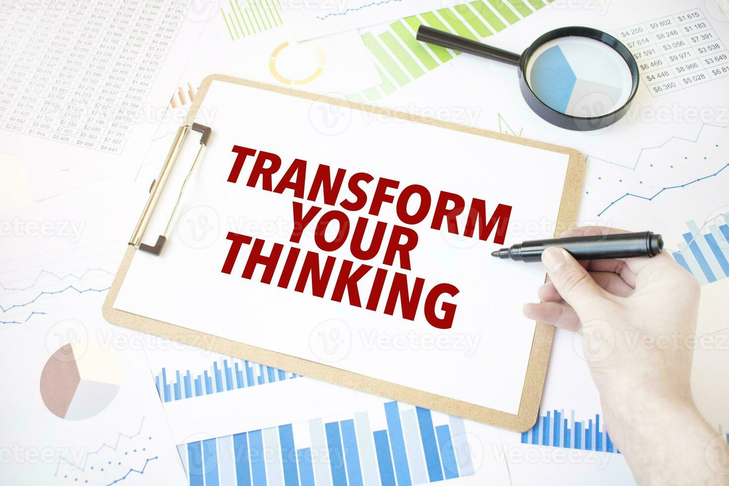 Text TRANSFORM YOUR THINKING on white paper sheet and marker on businessman hand on the diagram. Business concept photo