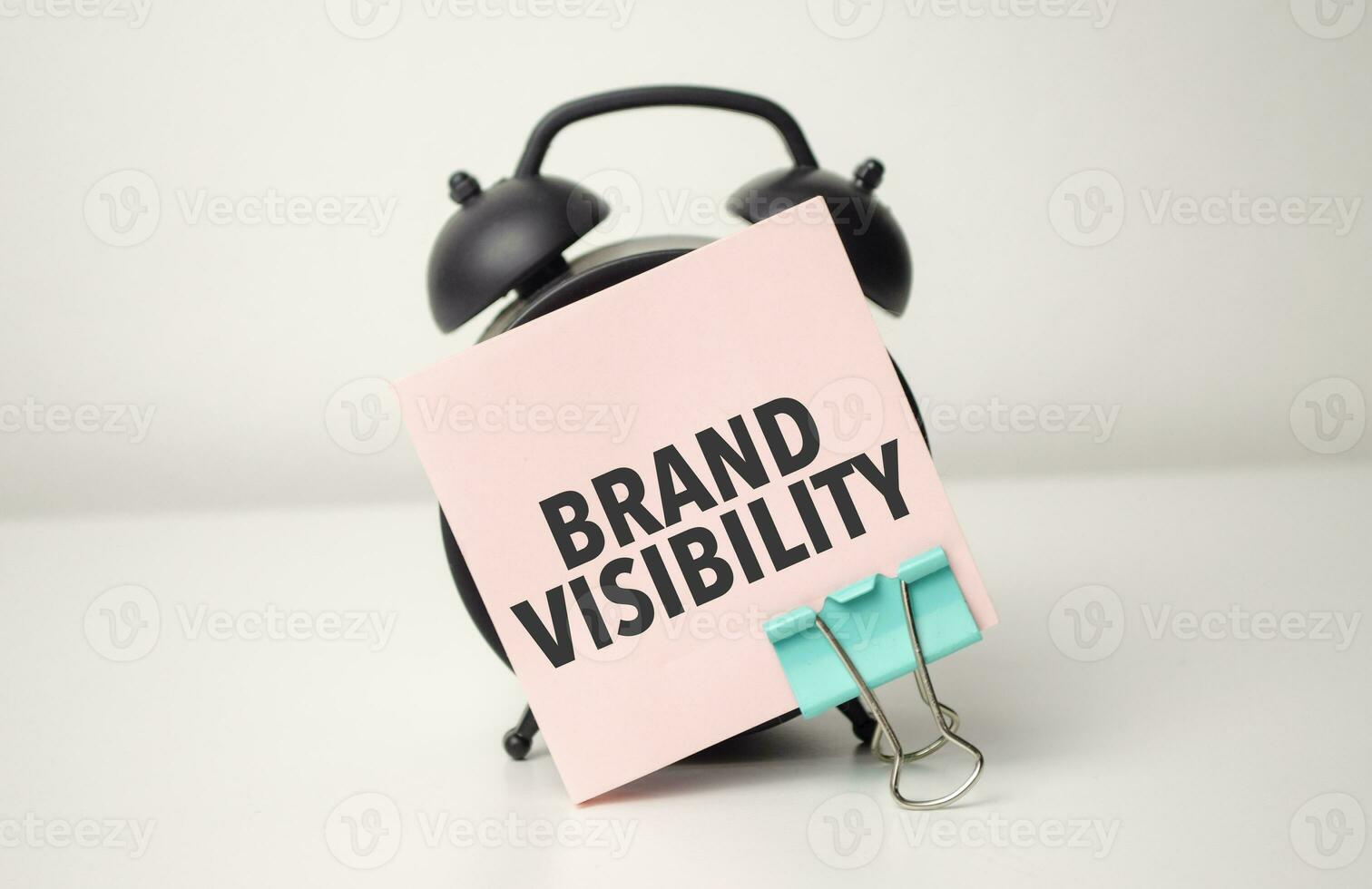 alarm clock with pink sticker with the text brand visibility photo