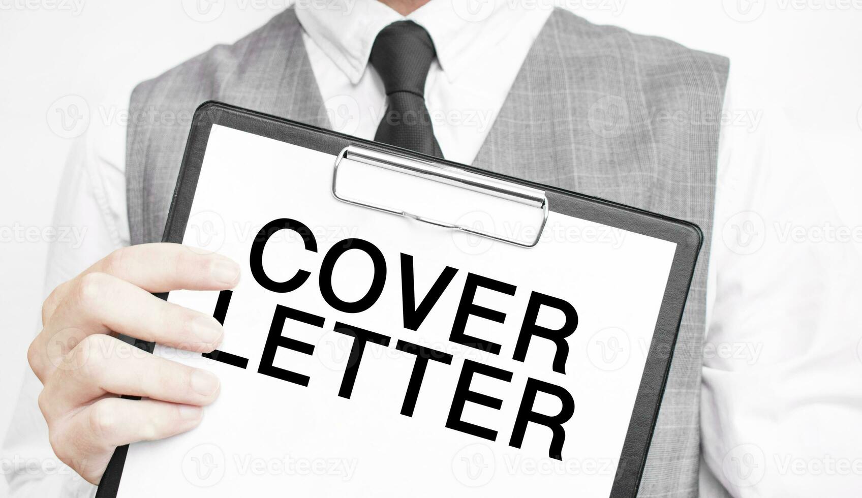 COVER LETTER inscription on a notebook in the hands of a businessman on a grey background, a man points with a finger to the text photo