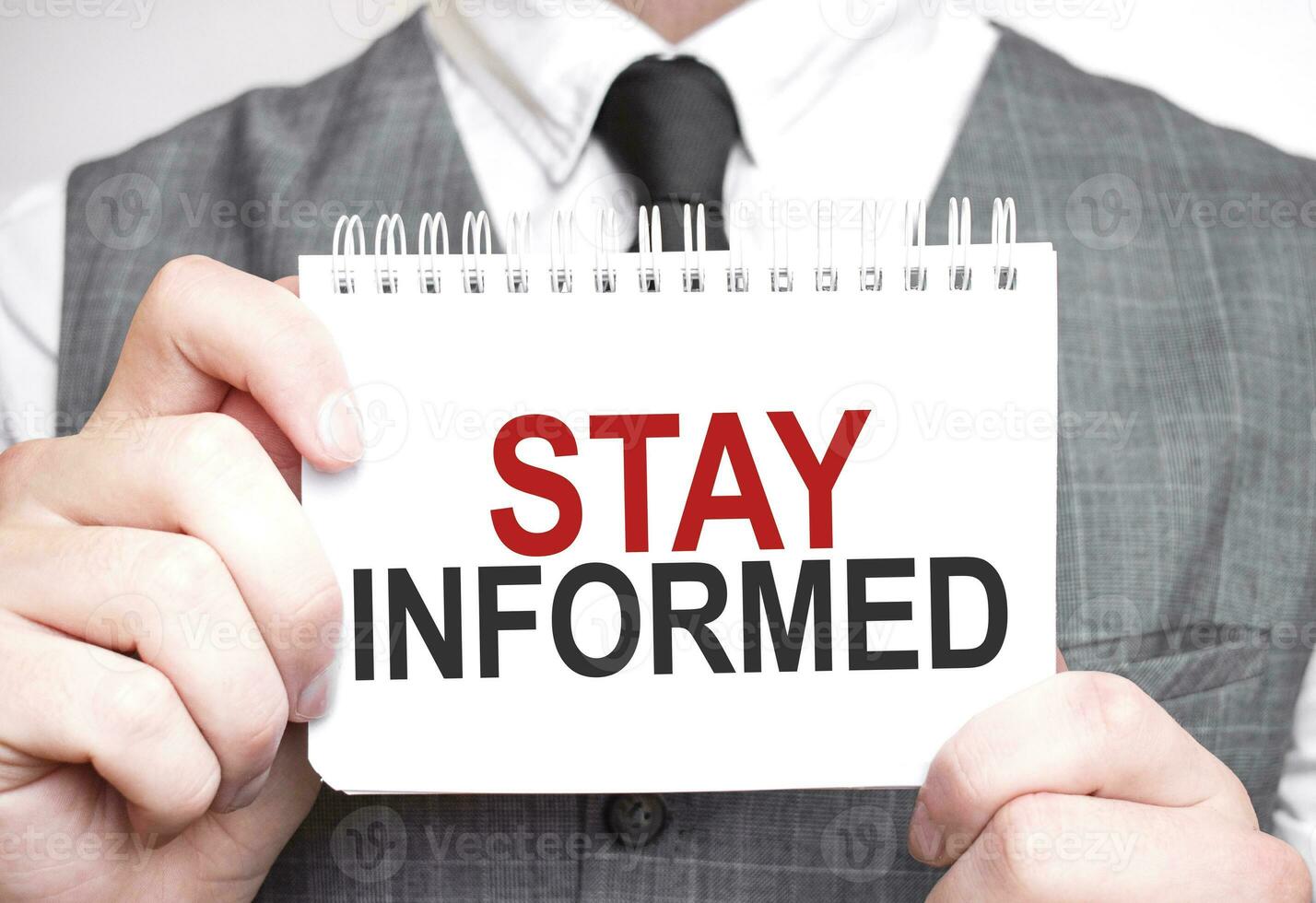 Businessman with notebook with text STAY INFORMED photo