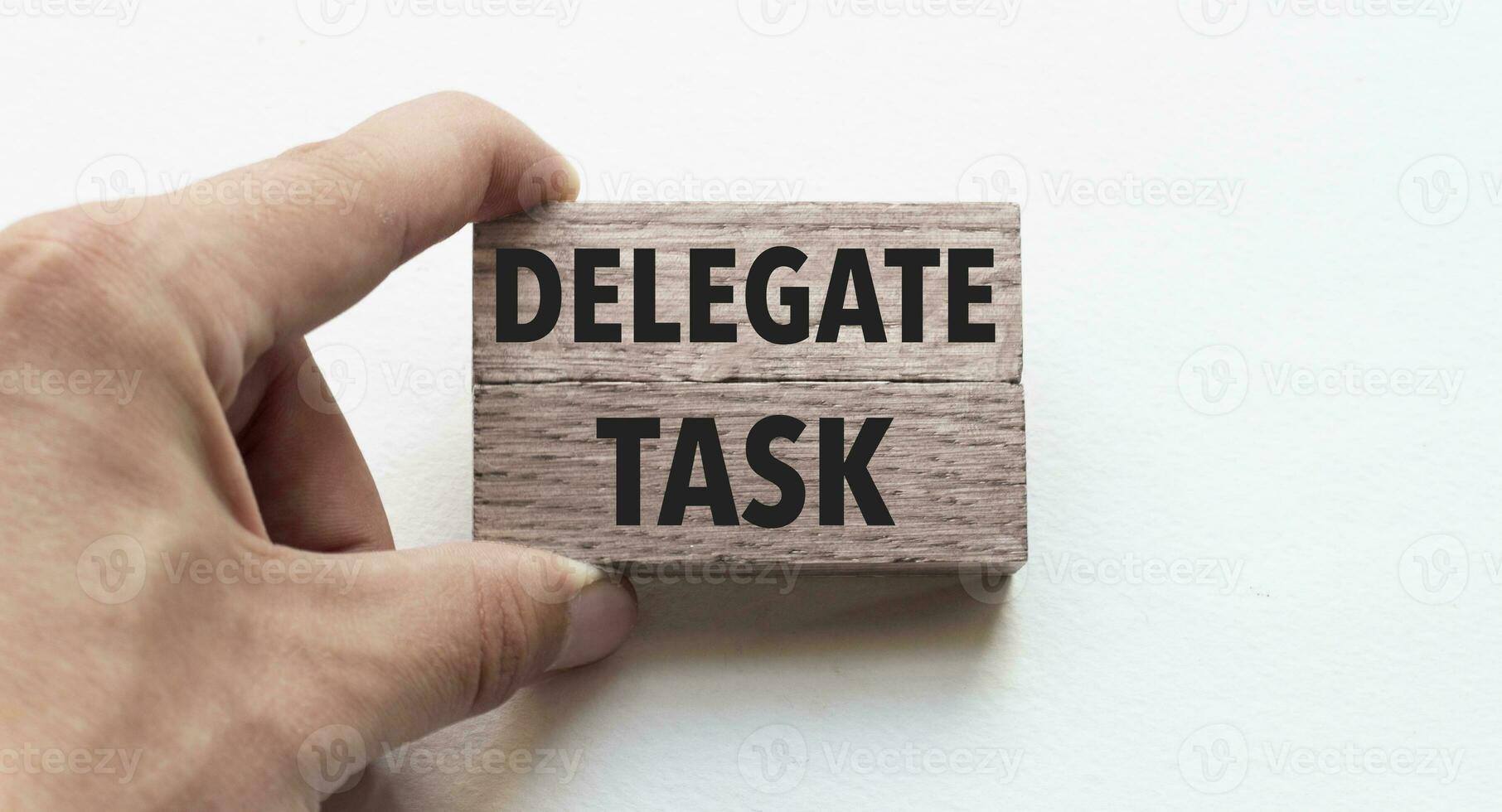 Hand of a businessman holding wooden blocks. Conceptual image. Text delegate task concept business succeed. photo