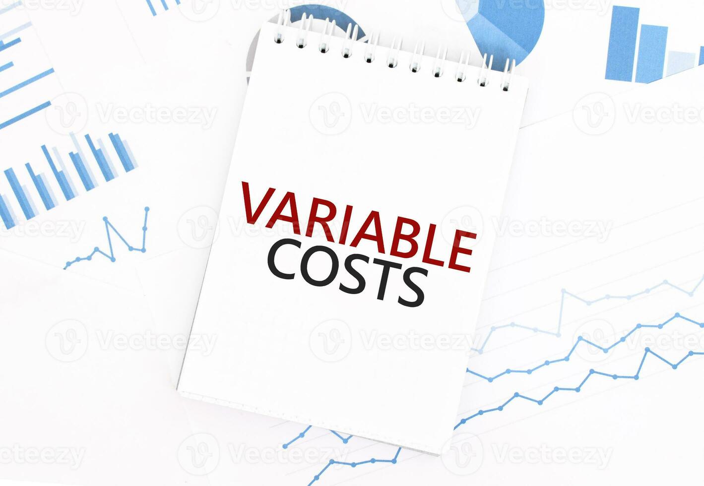 White notepad with text VARIABLE COSTS on the financial documentation. Finance and business concept photo