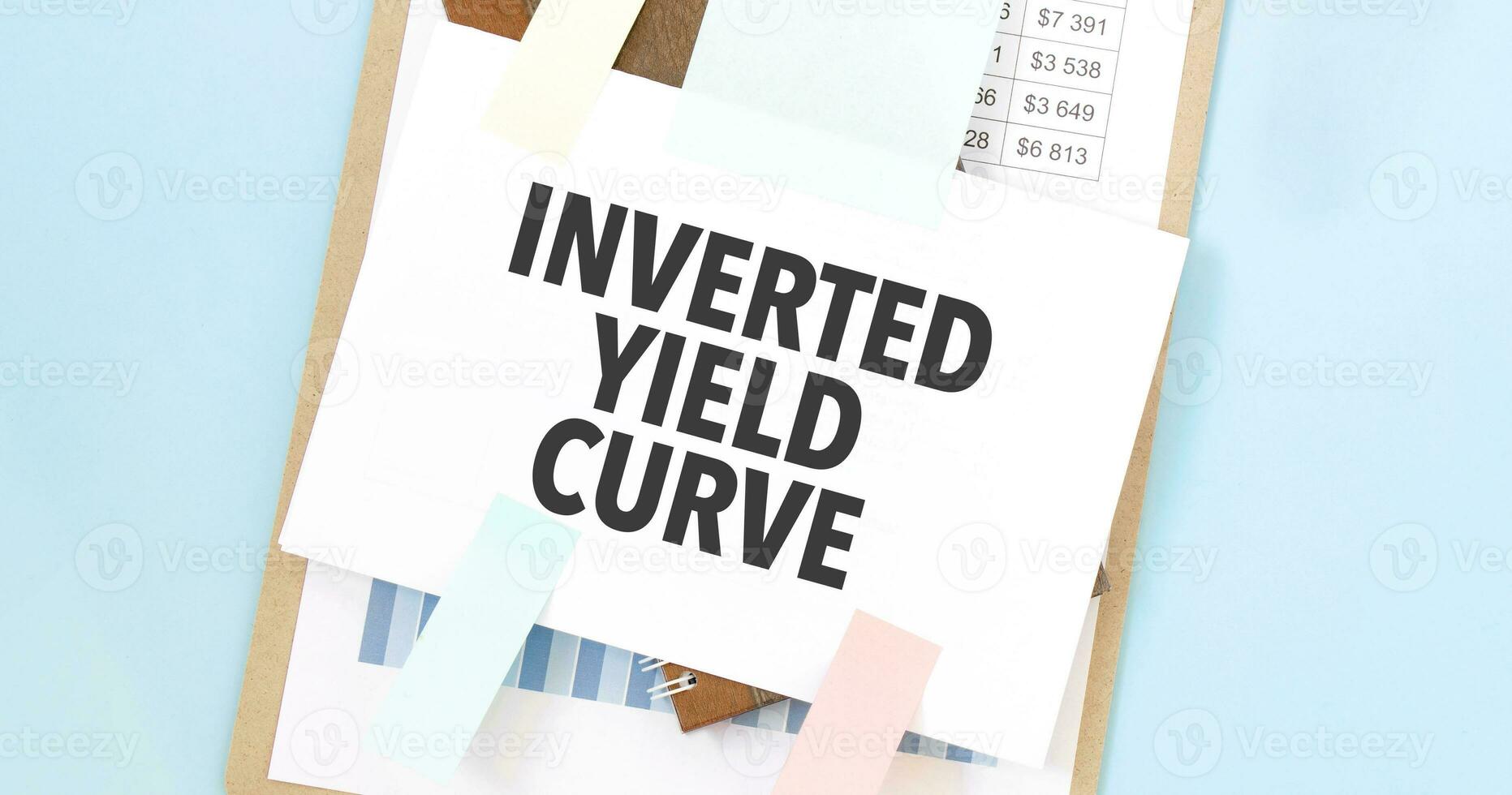 Paper plate with text take INVERTED YIELD CURVE. Diagram, notepad and blue background photo