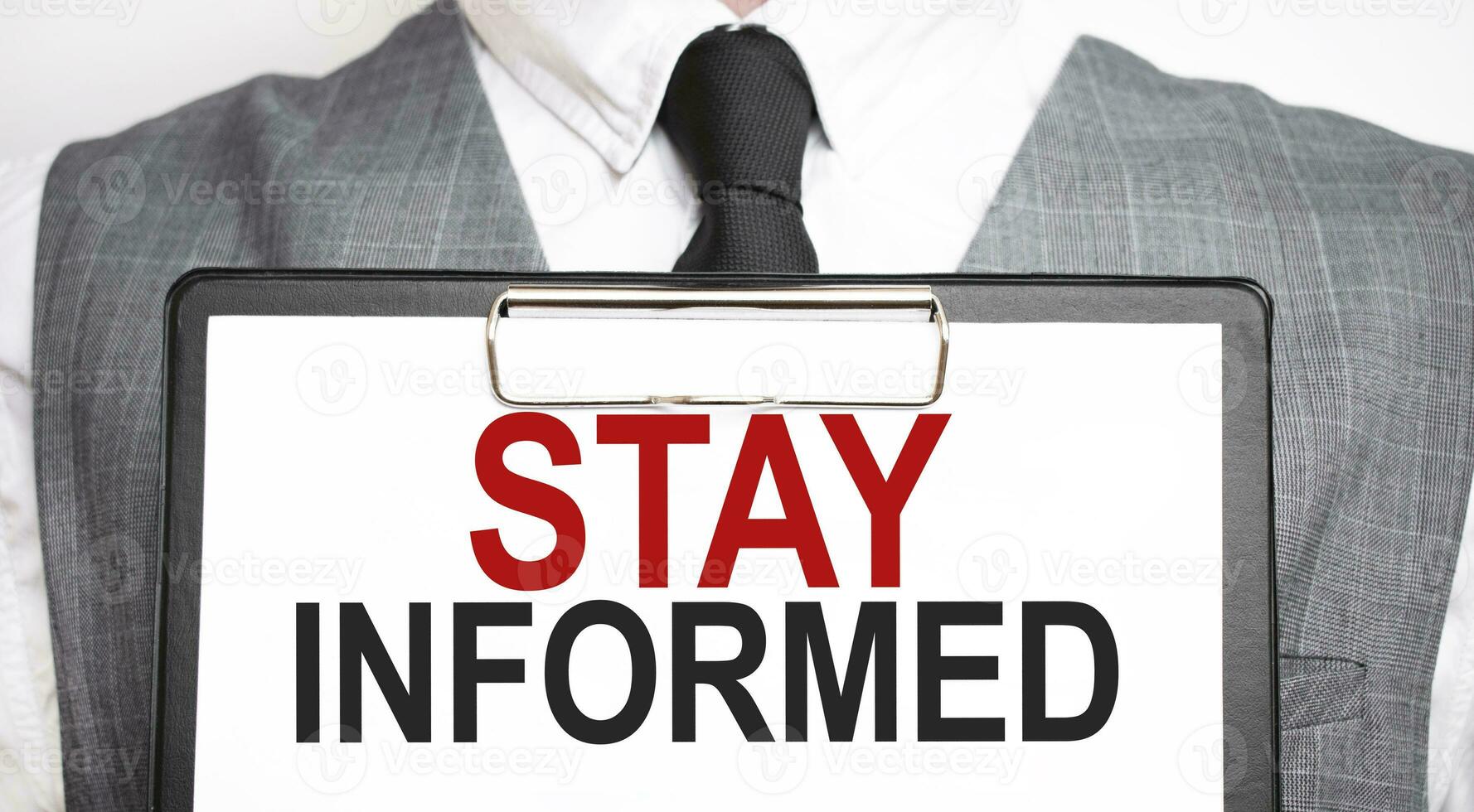 Businessman holding sheet of paper with a message STAY INFORMED photo