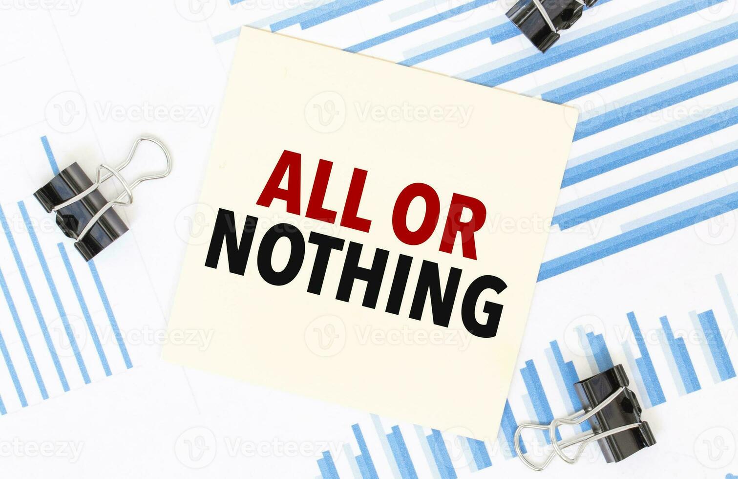 Yellow sticky notes with text ALL OR NOTHING on the white office desk. Business concept. photo