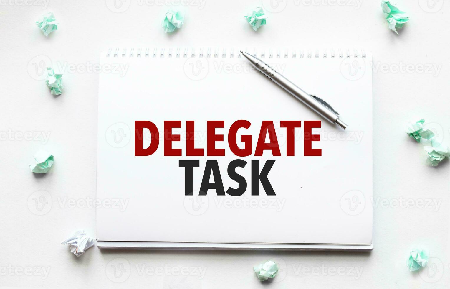 Blank sheet, pen and crumpled paper balls on grey table, flat lay. Text delegate task photo