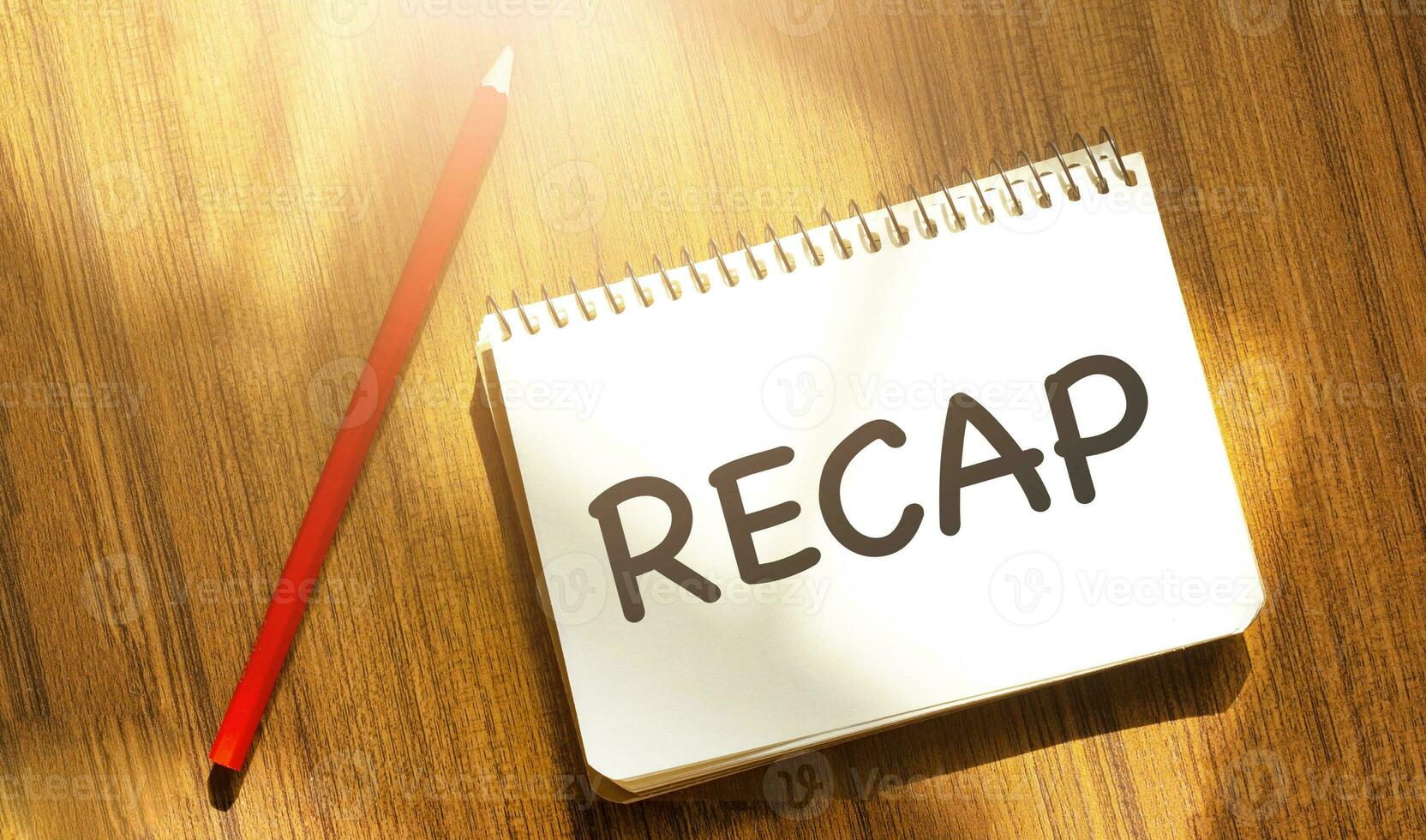 RECAP on yellow notebook with red marker and wooden background photo