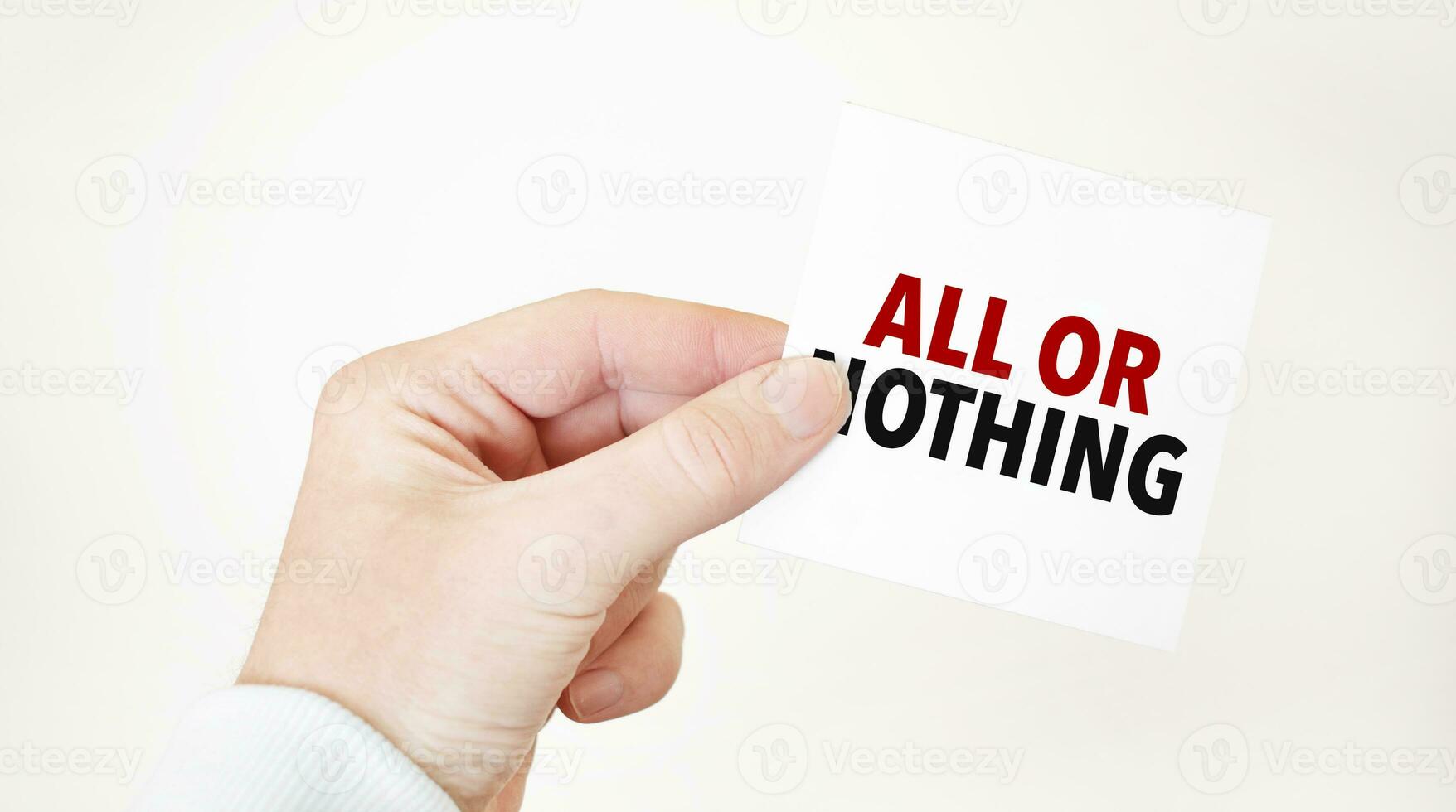 Businessman holding a card with text ALL OR NOTHING, business concept photo