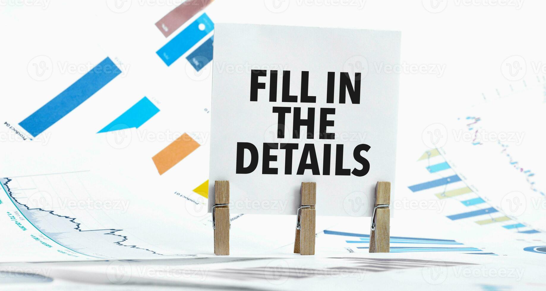 Text fill in the details on paper sheet with chart, dice, spectacles, pen, laptop and blue and yellow push pin on wooden table photo