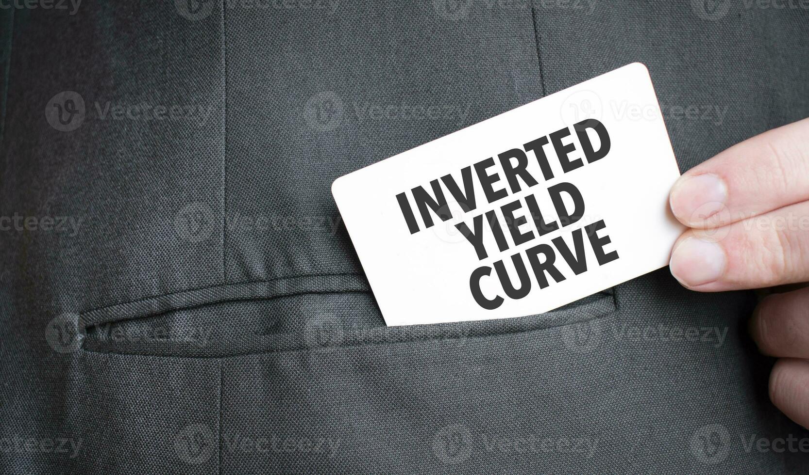 Card with INVERTED YIELD CURVE text in pocket of businessman suit. Investment and decisions business concept. photo