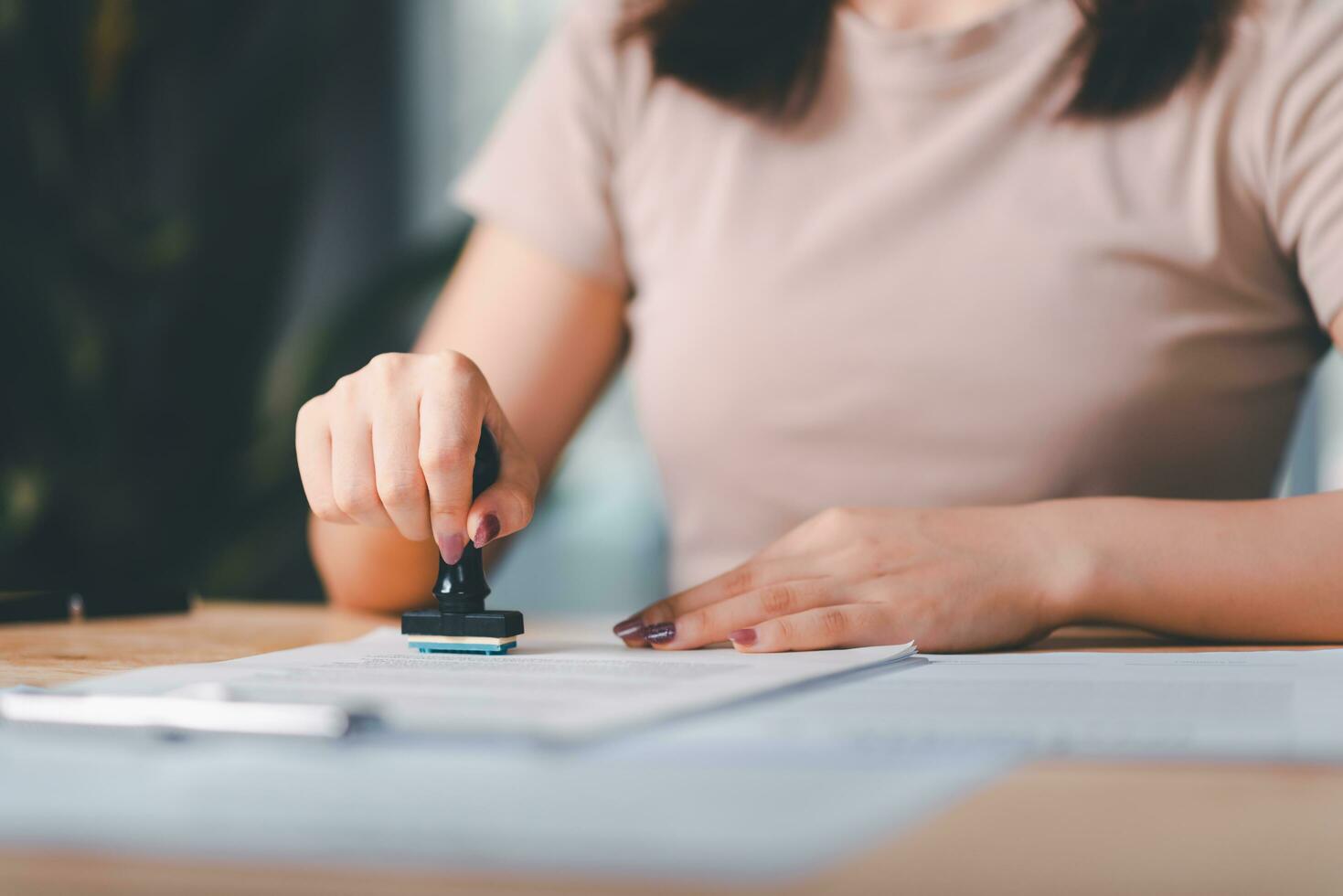 business woman validates and manages business documents and agreements ,approval stamp ,signing a business contract approval ,contract documents confirmation or warranty certificate ,Signing a form photo