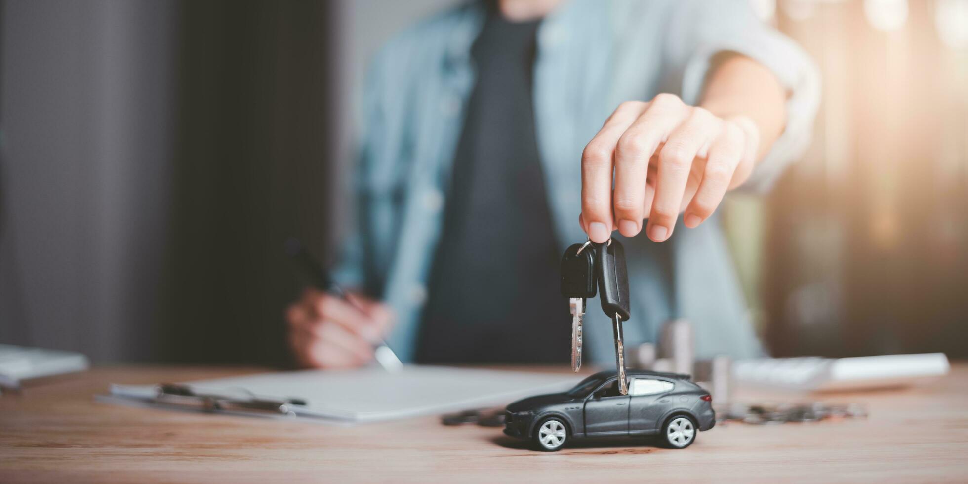 Car dealer and keys in hand ,Calculation of interest rates and car loan costs ,car purchase agreement ,Providing financial services and car insurance ,financial car loans ,Lease signing photo