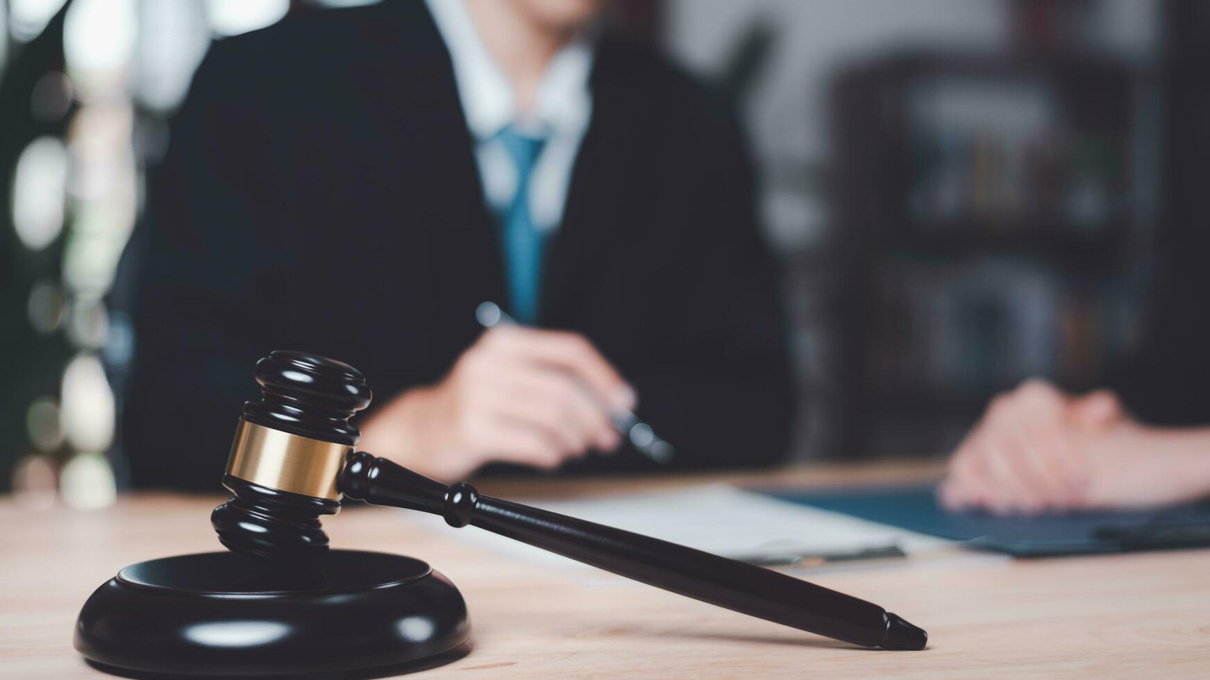 Wooden judge gavel on table ,justice in punishment of offenses and criminal verdicts ,concept of law and justice ,Lawyer or judge examining documents ,legal contract consulting ,court proceedings photo