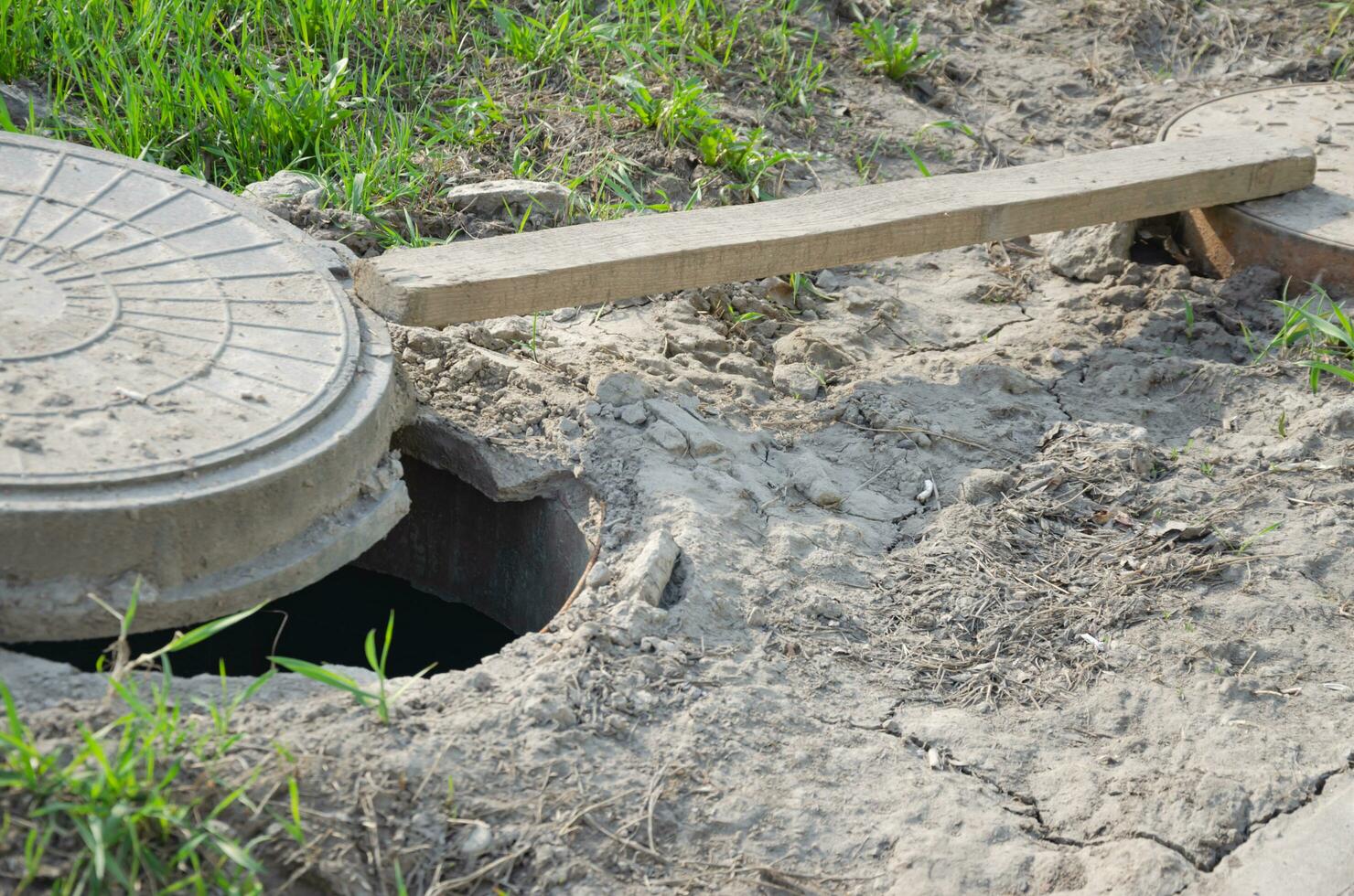 The hatch on the ground is open, the hole in the ground photo