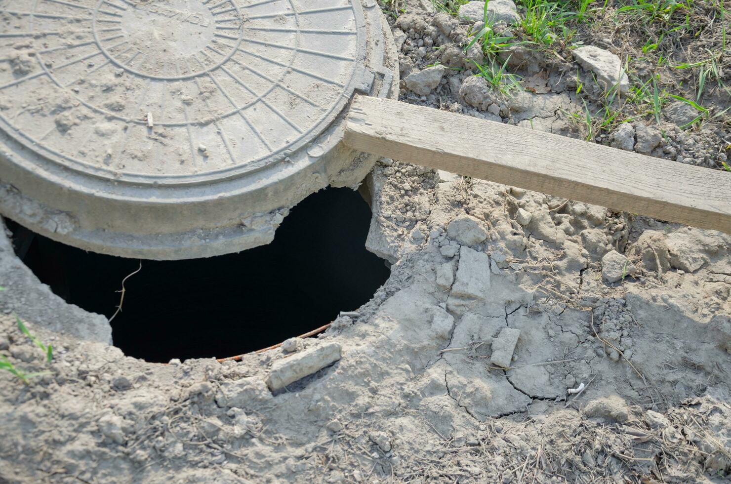 The hatch on the ground is open, the hole in the ground photo