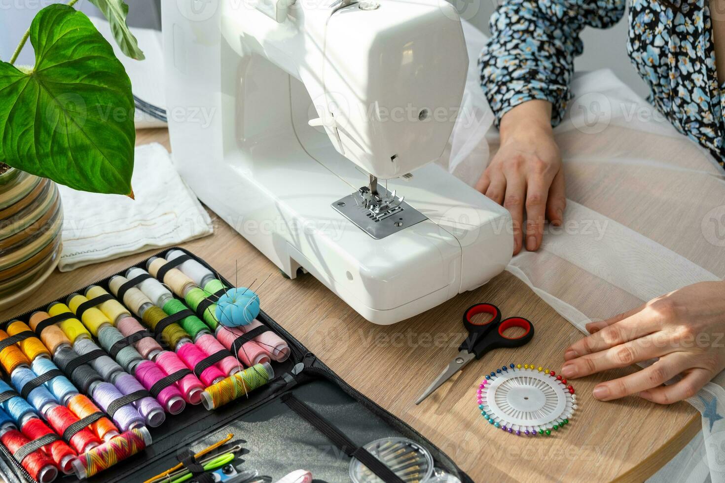 mujer mano cerca arriba cose tul en eléctrico de coser máquina. relleno el hilo dentro el de coser aguja, ajustando el tensión. comodidad en el casa, un ama de casa pasatiempo, diseño de de coser herramientas foto