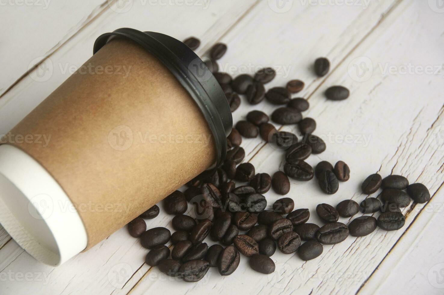 Takeaway coffee cup fall on coffee beans with customizable space for text or ideas. Copy space and coffee concept photo