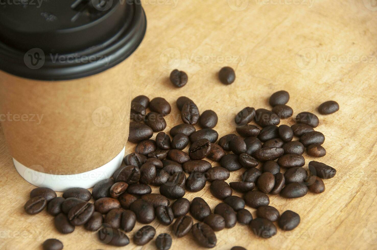 Takeaway coffee cup surrounded with coffee beans with customizable space for text or ideas. Copy space and coffee concept photo