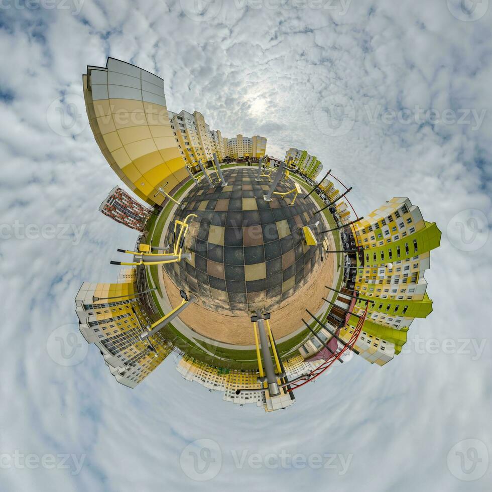 tiny planet in blue sky with clouds in city center near modern skyscrapers in residential complex. Transformation of spherical 360 panorama in abstract aerial view. photo