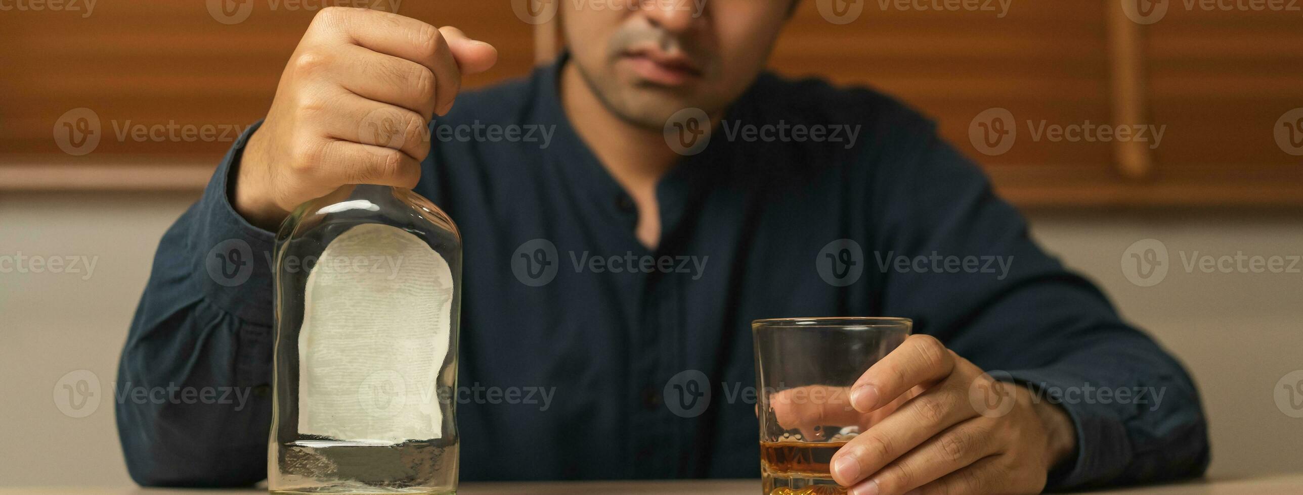 alcoholismo, Deprimido asiático joven hombre torrencial, participación botella whisky dentro el vaso, Bebiendo alcohol bebida a noche. tratamiento de alcohólico adiccion, sufrir abuso problema alcoholismo concepto. foto