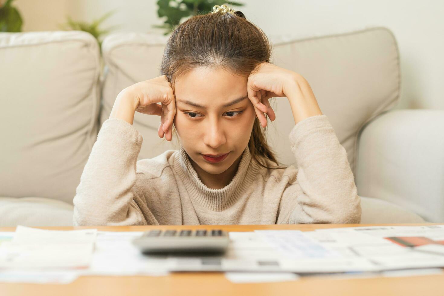 Financial owe asian young woman, girl sitting suffer, stressed and confused by calculate expense from invoice or bill, have no money to pay, mortgage or loan. Debt, bankruptcy or bankruptcy concept. photo