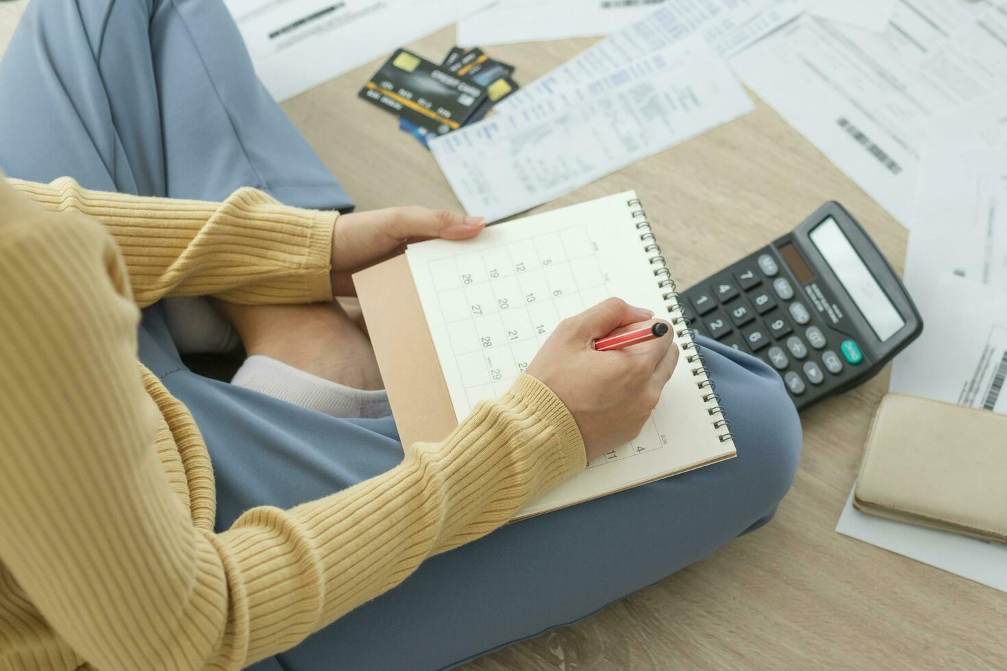 Top view owe, mortgage asian woman, female sitting on floor home, stressed calculate expense from bills, no money pay in mark circle deadline on calendar.Debt, bankruptcy or bankrupt person concept. photo